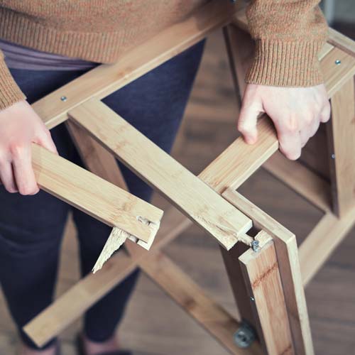 Photo of someone holding up a broken step ladder